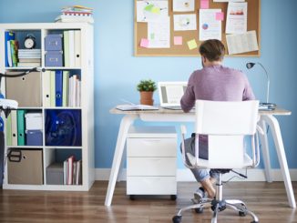 Ein junger Mann sitzt am Schreibtisch im Home Office