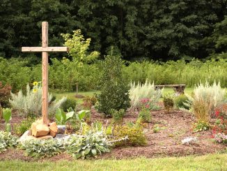 Ein Holzkreuz steht im Garten