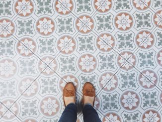 Eine Dame steht mit ihren Schuhen auf Zementfliesen