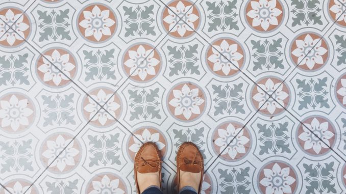 Eine Dame steht mit ihren Schuhen auf Zementfliesen