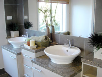 Ein Badezimmer mit zwei Waschbecken und Unterschränken in weiß