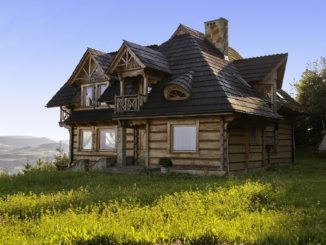 Modernes Holzhaus steht auf Wiese am Berghang