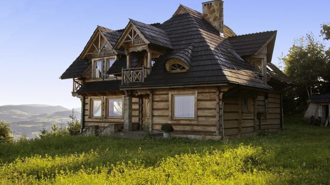 Modernes Holzhaus steht auf Wiese am Berghang