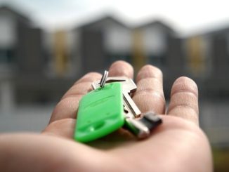 Eine Person hält einen Haustürschlüssel in der Hand