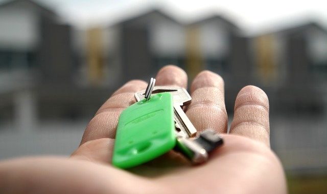 Eine Person hält einen Haustürschlüssel in der Hand